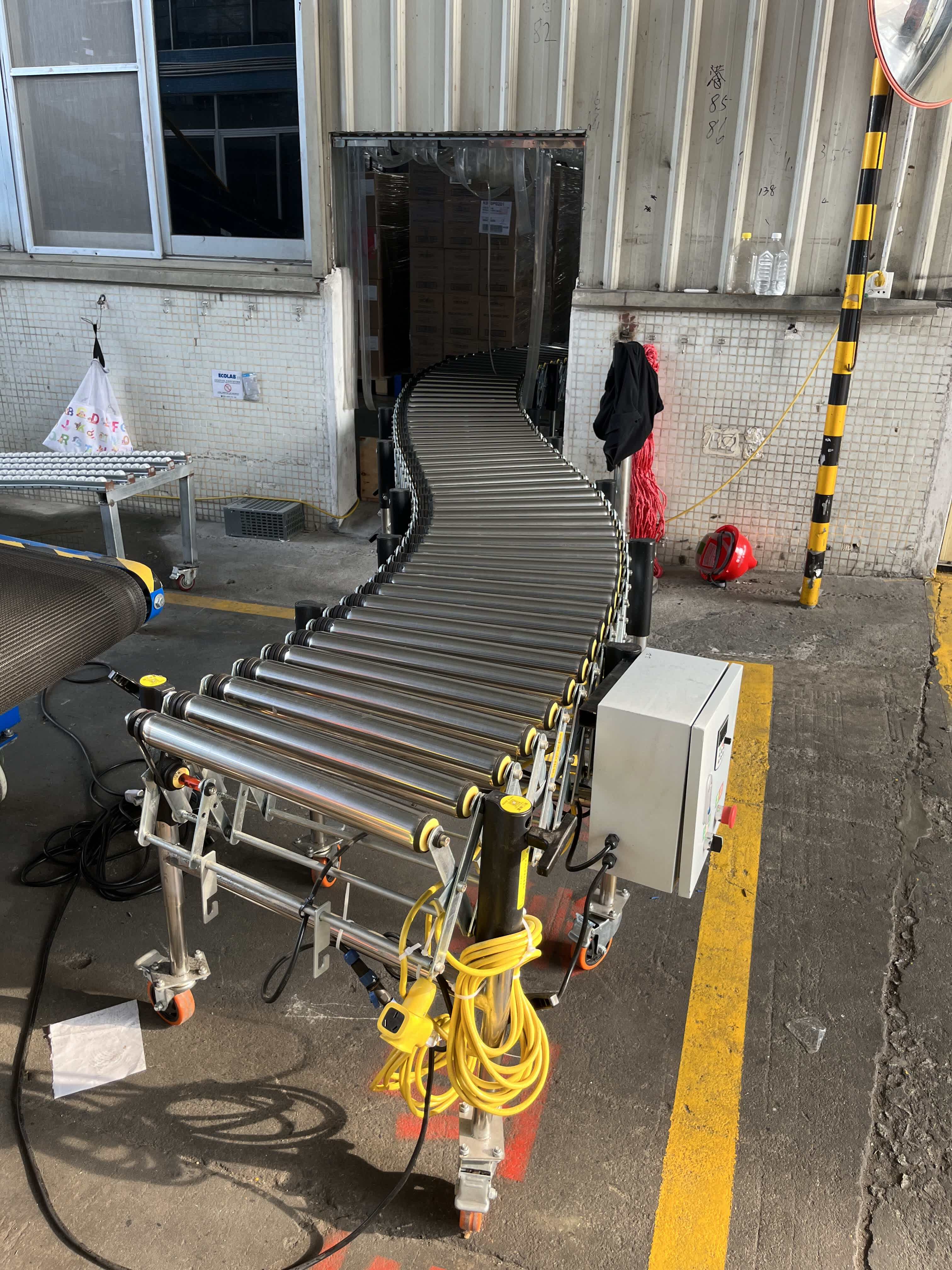 The roller conveyor extends from the warehouse to the loading and unloading area