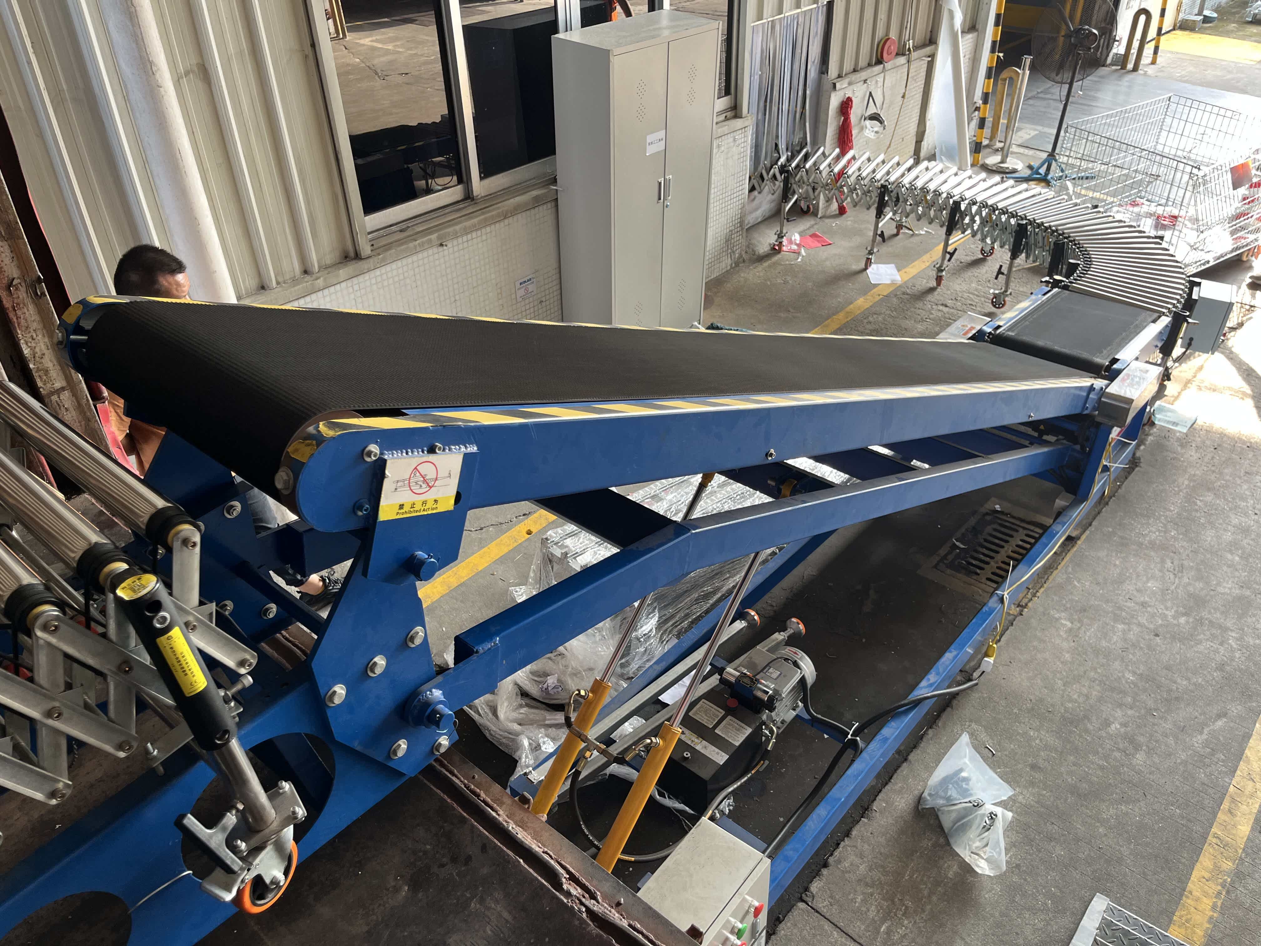 Side view of ramp conveyor roller conveyor extending into the truck bed