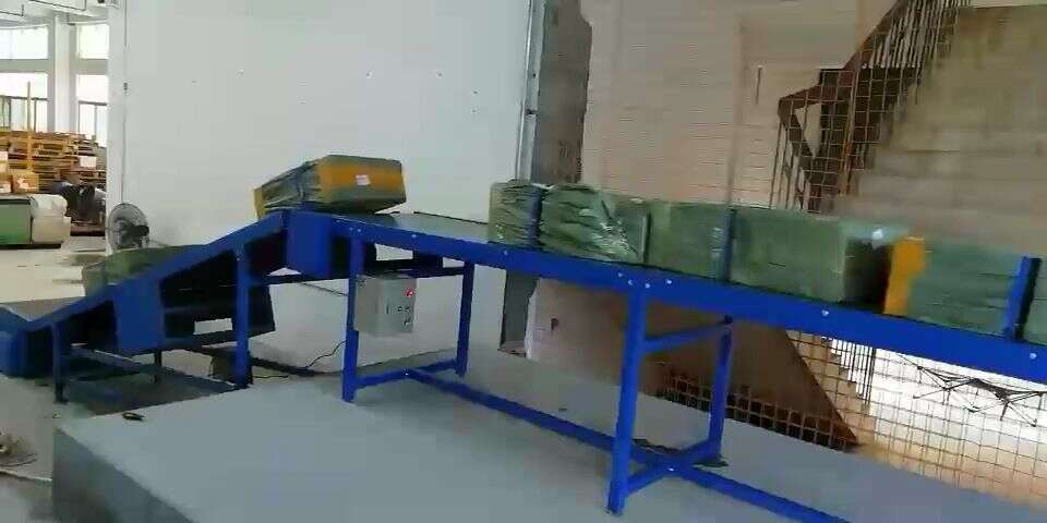 Demonstration of the telescopic conveyor receiving goods from the warehouse conveyance line and extending into the truck for loading and unloading.